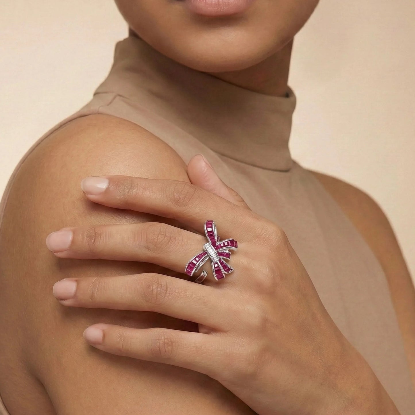 Woman wearing a Ruby Bow Ring on a beige background